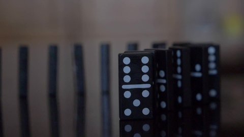 black dominoes falling in slow motion