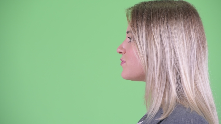 Closeup profile view of happy young blonde businesswoman talking