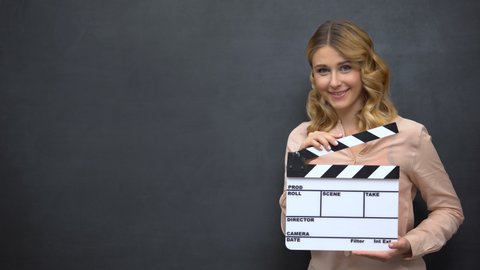 Beautiful girl using clapperboard, advertise of acting school, film production