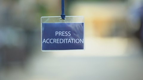 Press accreditation pass against blurred background, media ID card during event