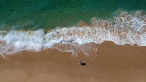 Aerial view solo woman walking on beach in Mexico on vacation