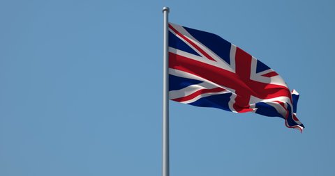 UK flag on flagpole. 4K 60fps. Britain Flag in Slow Motion. The United Kingdom of Great Britain and Northern Ireland flag waving in wind. Great for History, presentation with texts and corporate proje