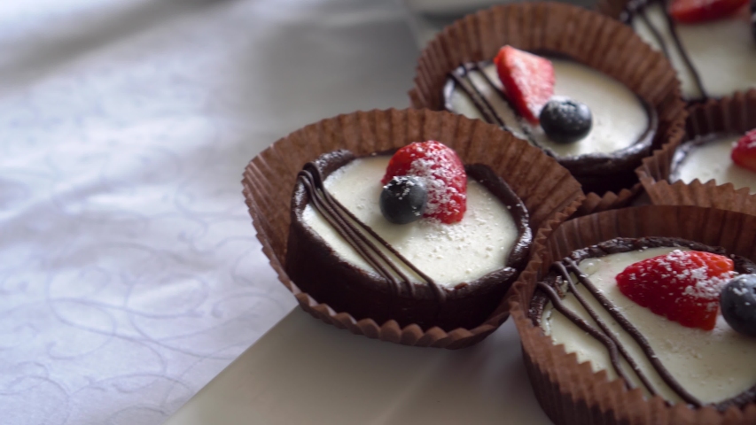 Vegan tartlets with strawberries and blueberries drizzled with dessert chocolate