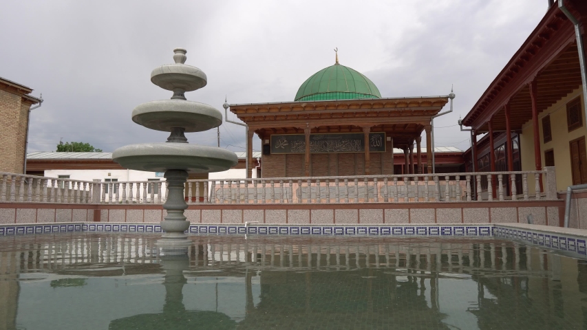 Istaravshan Hazrati Shoh Mosque with Mausoleum Fountain and Pond Frontal View on a Cloudy Rainy Day