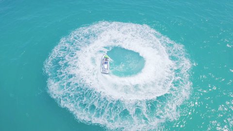Incredible aerial view of girl racing on water scooter in beautiful crystal clean blue water. Epic shot of Adult Woman enjoying summer vacation on jet ski. Watercraft adventure day in summer  holiday.