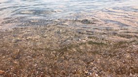 Sea water pattern of splashing waves, stones in the water, beautiful view in Corfu, Greece. 4K UHD video.