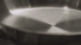 Close-up on frying pan add oil. Slow motion video