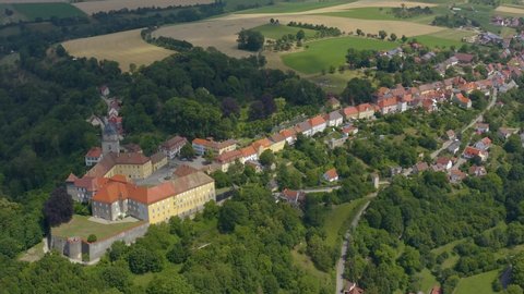 Aerial view of the village and palace Schloss Bartenstein in Germany. Pan to the right above the village and palace.