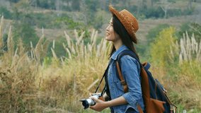 Video 4k of tourist woman taking a photo with her camera in nature