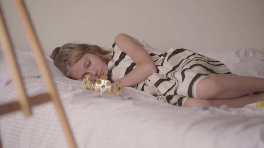 Cute sleeping calm caucasian girl lying in his comfortable bed. The child resting after playing games. Carefree childhood, resting at home