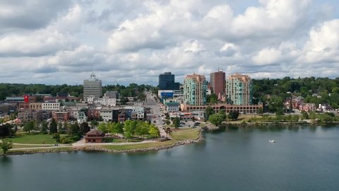 Barrie, Ontario, Canada - Aug 6, 2019: City of Barrie waterfront and downtown aerial drone dolly shot with Lake Simcoe marina, condo buildings, banks, parks and infrastructure. Cloudy summer day.