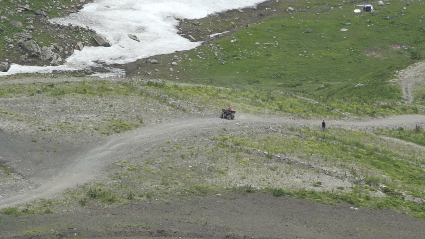 Aerial view of Driver Driving a Sports Atv on the Dirt Road. Atv Rides on Mountain Trail