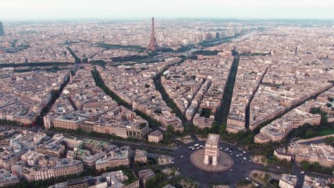 Aerial drone shot of the Cityscape of Paris, France with the Arc de Triomphe in the foreground and the famous Eiffel Tower in the background