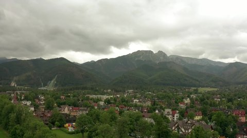 Drone shot on a tourist town rooted in the mountains. City landscape on a summer cloudy day.  Aerial view of the tourist cities of Zakopane in Poland.