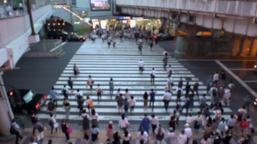 UMEDA, OSAKA, JAPAN - CIRCA JULY 2019 : Aerial blurred view of zebra crossing near Osaka train station. Crowd of people at the street. Shot in busy rush hour.