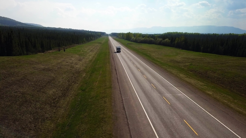 Aerial View of overlanding 4x4 RV driving a remote stretch of the Alaska highway in Northern British Columbia, Canada.