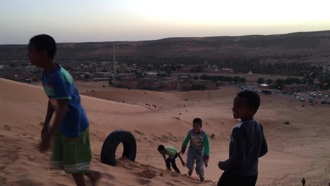 Taghit, Bechar, Algeria - November 03, 2017: Tuareg children are playing on dunes of Sahara Desert.