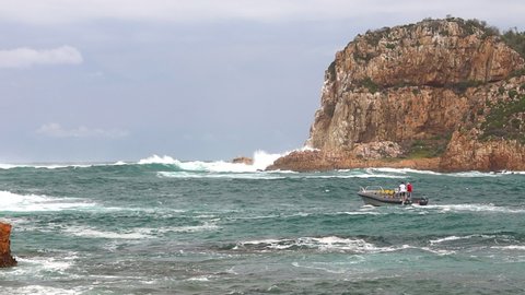 A commercial passenger vessel slowly investigates the Knysna Heads before turning back because of the danger