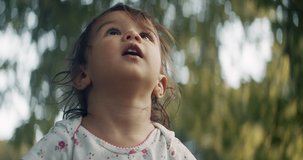 Cute baby girl exploring a park in summer. Real life, candid footage. Shot in 4K RAW on a cinema camera.