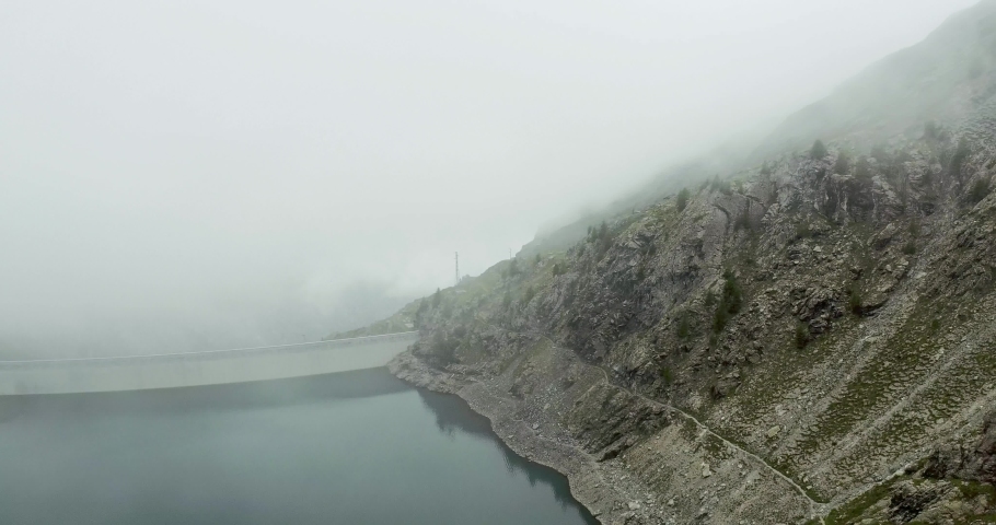 aerial establisher flight over italian alps mountain riff climbing. Wild green nature outdoor in foggy or cloudy weather. above 4k drone truck