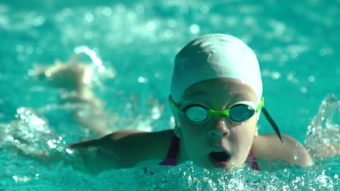 Amateur female athlete doing butterfly stroke during training in indoor swimming pool, Slow motion, Full HD steady shot.