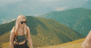 Happiness couple tourist traveler handshake and walking on the top of mountain in summer sunny day under sun light. Beautiful mountains landscape view. 4K slow motion video

