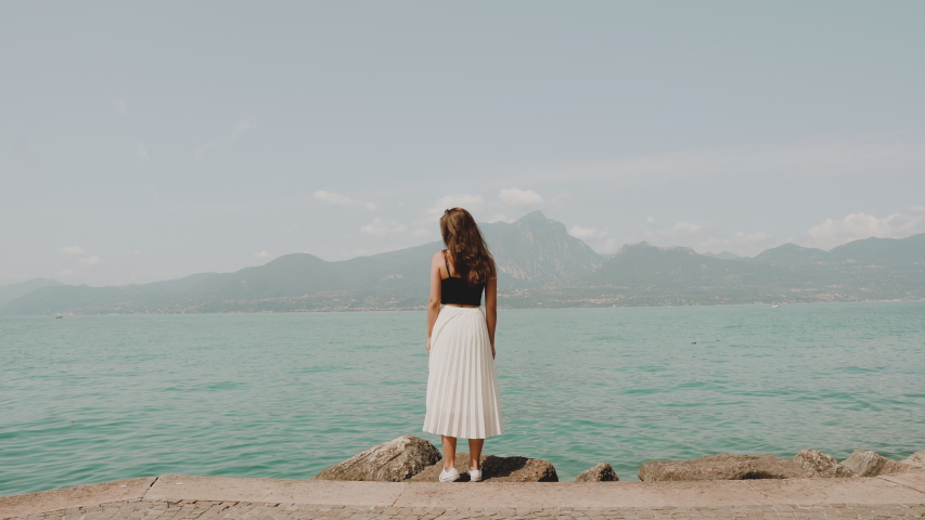 Beautiful pretty model slim girl with long hair in white skirt enjoying lake garda italy August 2019
long shot wide shot