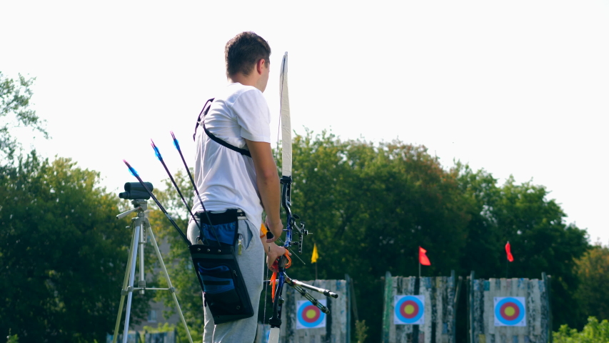 Male archer training on a range with targets.