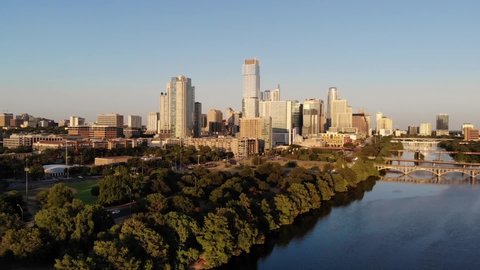 Aerial Drone shot of Downtown Austin, Texas. Shot from the Southwest, coming from Zilker park. Coming over the trees revealing town lake and the downtown skyline.