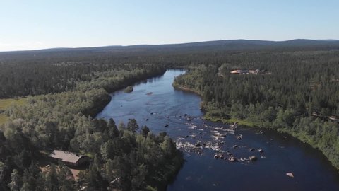 Aerial drone view over a fast river.Pine forests around