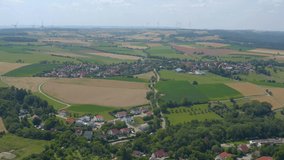 Aerial view of the village and castle Kirchberg an der Jagst in Germany on a sunny day. Tilt down from horizon to village and castle.