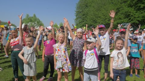 KOZACHI LAGERYA, UKRAINE- JUNE 01, 2019: Children Protection Day, a group of happy active orphan children wave their hands have fun and jump during holiday on a sunny weekend