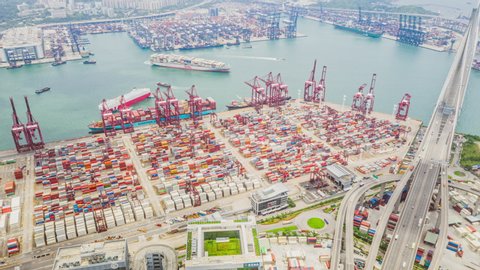 Hong Kong, Hong Kong - Jul 8, 2019: hyperlapse time-lapse of Hong Kong port with cargo container ship, crane, and car traffic. Logistic industry or freight transportation concept, drone aerial view