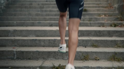 Running On Up Steps.Slow Motion Runner Training For Triathlon Competition.Sportsman Cardio Endurance Exercise.Runner Jogging On Stairs.Running Man Workout Before Half Marathon Race.Jogger Athlete Legs