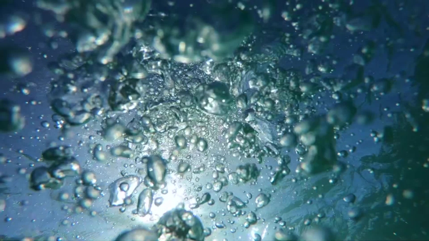 Underwater slow motion video of diver releasing air bubbles flowing towards sea surface in tropical exotic bay