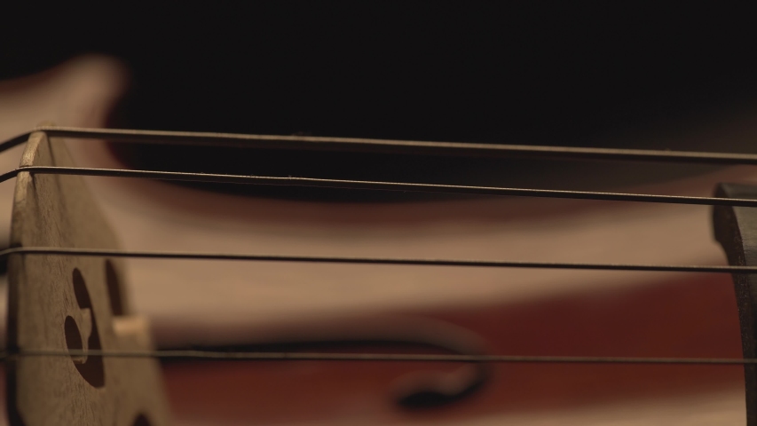 Macro close up of cello, cello bow , cello playing and strings pulsing, music video , cello player | Shutterstock HD Video #1036086893