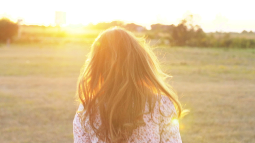 Cute woman walking on the street look at camera spinning. Happy smile beautiful portrait, silhouette. Close up