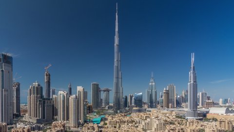 Dubai Downtown skyline all day timelapse with Burj Khalifa and other towers paniramic view from the top in Dubai, United Arab Emirates. Shadows moves very fast. Traffic on circle road and fountains