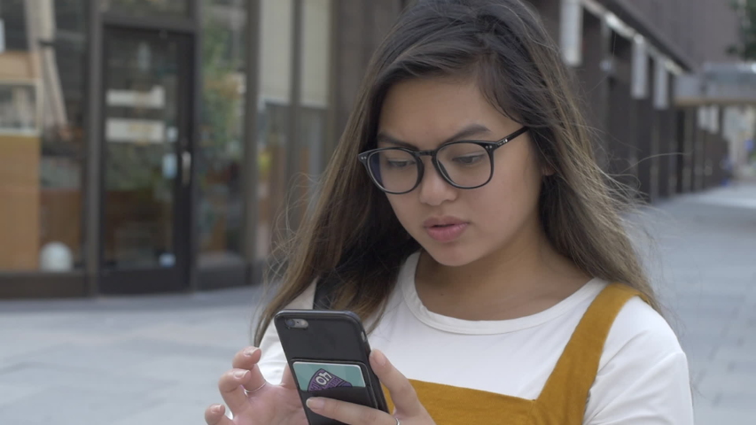 Girl in City Scrolling through Phone
