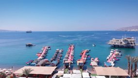 Aerial Footage over Deck Marina With Speed boats Desert mountains and blue sea