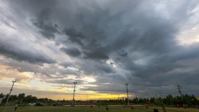 Time lapse sunset dark clouds and turbulent skies accompany a strong thunderstorm Above football field