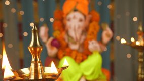 Shot of Lord Ganesha idol on Ganesh Chaturthi - Indian Festival. Burning lamps in front. Decorated Ganesh Ji Idol kept on a decorated platform - Indian festival for Hindus. Colorful festive backgro...