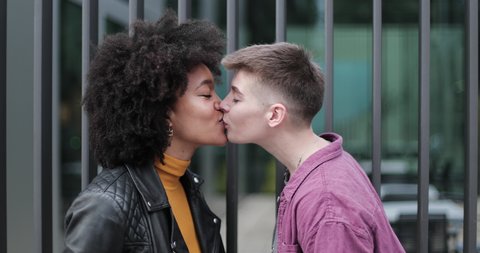 Young adult lesbian couple kissing outdoors in city Video stock