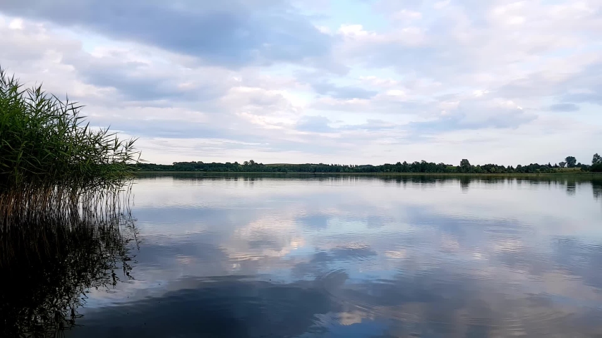 Lake Timelapse. Timelapse Of A Peaceful Lake And Mooving Clouds. Motion Timelapse Left To Right Pan. Evening Sky And Coluds Over A Lake.