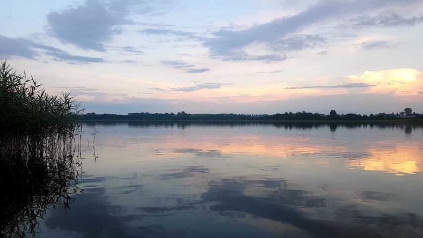 Lake Timelapse. Timelapse Of A Peaceful Lake And Mooving Clouds. Daylight To Dusk Motion Timelapse. Sky And Coluds Over A Lake.