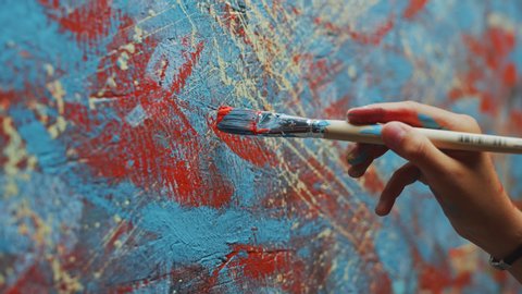 Close-up Shot of Female Artist Hand, Holding Paint Brush and Drawing Oil Painting. Colorful, Emotional Oil Painting. Contemporary Painter Creating Modern Abstract Piece of Fine Art