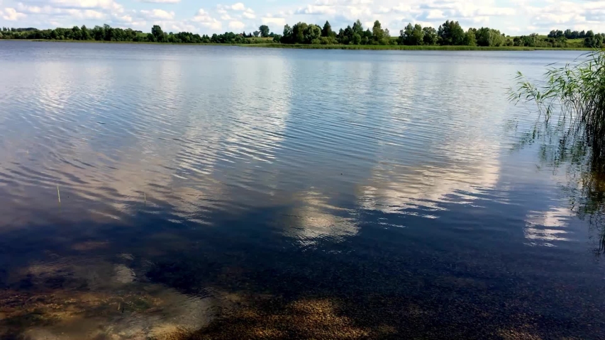 Lake Timelapse. Timelapse Of A Peaceful Lake And Mooving Clouds. Sky And Coluds Over A Lake. Low To High Camera Tilt.