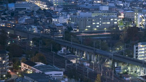 Timelapse of bullet trains and subway trains converging at train intersection at rush hour twilight, heading towards Train station.