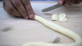 Slow motion video of hands of woman making orecchiette pugliesi pasta  from dough process. Typical italian food from Apulia, Puglia