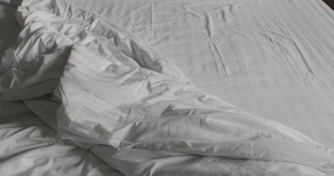 Crumpled messy white blanket untidy, Unmade bed after waking up in the morning with a duvet on the bed.